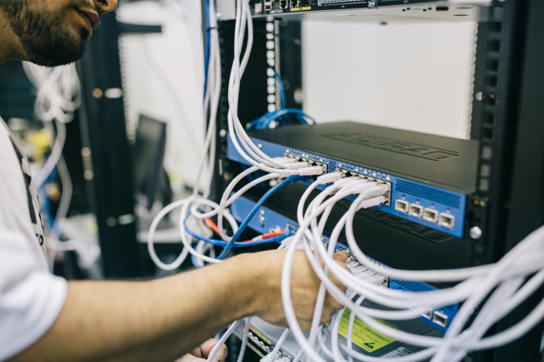 Network FieldEngineer working on rack switches and cabling for Network Support Services